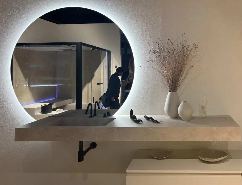 EuroCucina 2026 bathroom with tone-on-tone orange vanity, mirror, and walls, decentered mirror design, Salone del Mobile Milano