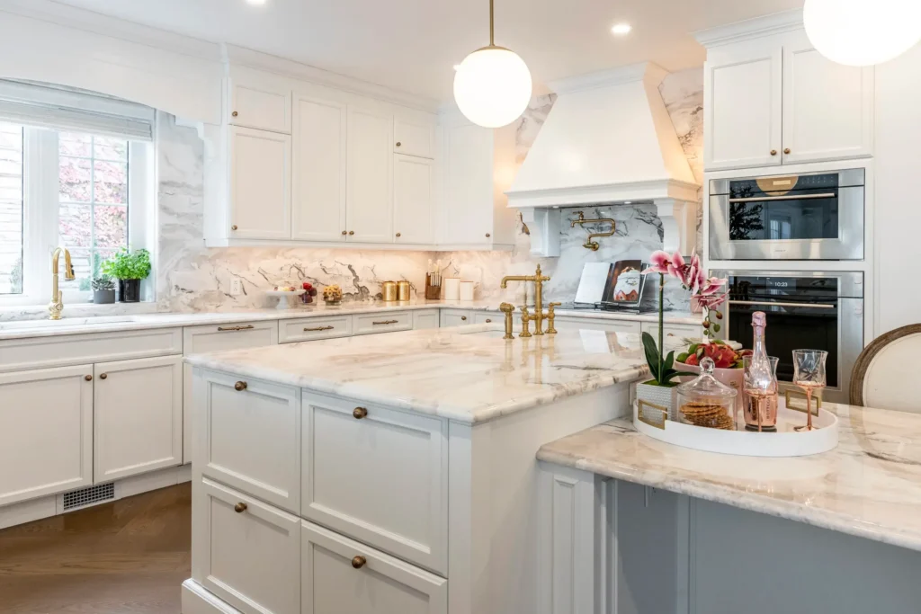 Armoires de cuisine Laval laquées avec quincaillerie dorée et marbre rosé — rénovation cuisine Laval